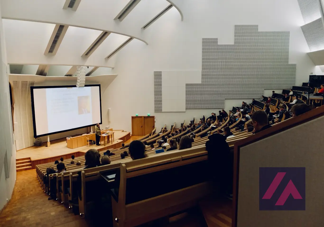 Salle de classe universitaire remplie d'étudiants pendant un cours.